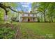 Beautiful home featuring a large manicured lawn, mature trees, and an inviting front porch with classic columns at 740 Woodlawn Ave, Mount Holly, NC 28120