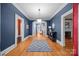 Spacious foyer featuring hardwood floors, blue walls, white trim, and a view of the staircase at 740 Woodlawn Ave, Mount Holly, NC 28120