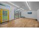 Bright garage interior featuring a glass door, ample lighting, and hardwood flooring at 740 Woodlawn Ave, Mount Holly, NC 28120