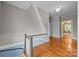 A second story hallway with a stairwell, showing a view into a yellow living room area at 740 Woodlawn Ave, Mount Holly, NC 28120