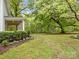 A large, green backyard with a stone path, lush trees, and beautiful landscaping at 740 Woodlawn Ave, Mount Holly, NC 28120