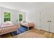 Bright bedroom with two beds, natural light from two windows and wood flooring at 7514 Pewter Ln, Charlotte, NC 28270