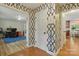Hallway with patterned wallpaper, wood floors, and views into adjacent rooms at 7514 Pewter Ln, Charlotte, NC 28270
