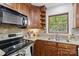 Kitchen featuring granite countertops, custom cabinetry, stainless steel appliances, and window above sink at 7514 Pewter Ln, Charlotte, NC 28270