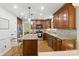 Well-lit kitchen featuring custom cabinetry, stainless steel appliances and granite countertops at 7514 Pewter Ln, Charlotte, NC 28270