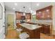 Kitchen with a central island, wooden cabinetry, stainless steel appliances, and hardwood flooring at 7514 Pewter Ln, Charlotte, NC 28270