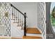 Hallway staircase with a blend of wood and white finishes, accented by patterned wallpaper at 7514 Pewter Ln, Charlotte, NC 28270
