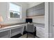 Bright home office features sleek gray cabinets, a large window, and built-in desk space for comfortable work at 9611 Pensive Ln, Waxhaw, NC 28173