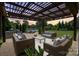 Inviting outdoor living space features a covered patio with comfortable seating overlooking a serene pond at 9611 Pensive Ln, Waxhaw, NC 28173
