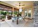 Inviting covered patio with a dining table and a view of the picturesque backyard pond at 9611 Pensive Ln, Waxhaw, NC 28173