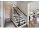 Elegant staircase leading to the upper level with dark wood and white risers at 9611 Pensive Ln, Waxhaw, NC 28173