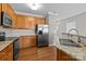 Kitchen with stainless steel refrigerator, wood cabinets, and granite counters at 1001 Woodglen Ln, Matthews, NC 28104