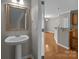 Powder room featuring a pedestal sink and mirror at 1001 Woodglen Ln, Matthews, NC 28104