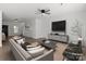 Open-concept living room with modern furniture, ceiling fan, and view of the stairs at 1041 Secor St, Statesville, NC 28677