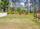 Expansive backyard featuring a new playset and lush green lawn and privacy fence at 1045 Cavalier Ln, Rock Hill, SC 29730