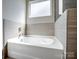 Bathroom featuring a modern soaking tub with light brown tile surround and natural lighting at 1045 Cavalier Ln, Rock Hill, SC 29730