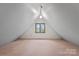 Spacious carpeted attic with a centered window and ample natural light at 1074 Oakridge Farm Hwy, Mooresville, NC 28115