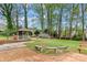 Serene backyard featuring a gazebo, mature trees, stone benches, and a well-maintained lawn at 1074 Oakridge Farm Hwy, Mooresville, NC 28115