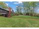 Expansive backyard with lush lawn, mature trees, garden areas, gazebo and swing set for outdoor enjoyment at 1074 Oakridge Farm Hwy, Mooresville, NC 28115