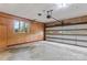 Spacious garage featuring wood paneling, storage, and a large garage door at 1074 Oakridge Farm Hwy, Mooresville, NC 28115