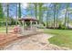 Relaxing gazebo with seating area in a lush backyard setting surrounded by mature trees and manicured landscaping at 1074 Oakridge Farm Hwy, Mooresville, NC 28115