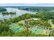 An aerial view shows several tennis courts, a playground, a pool, and a lakeside community at 10915 Hermit Thrush Ln, Charlotte, NC 28278