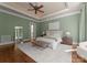 This spacious bedroom has hardwood floors, ceiling fan, and a bench at the end of the bed at 10915 Hermit Thrush Ln, Charlotte, NC 28278