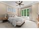 This bedroom has carpet floors, a ceiling fan, and a large window at 10915 Hermit Thrush Ln, Charlotte, NC 28278