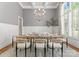 Elegant dining room features wainscoting, coffered ceiling, stylish chandelier, and large window at 10915 Hermit Thrush Ln, Charlotte, NC 28278