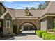 View of porte-cochère showcasing its unique architecture, arched entryways, and well-maintained landscape at 10915 Hermit Thrush Ln, Charlotte, NC 28278