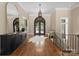 Inviting foyer featuring hardwood floors, ornate iron staircase, and an elegant chandelier at 10915 Hermit Thrush Ln, Charlotte, NC 28278