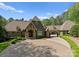 Stunning home features a circular driveway and porte-cochère, all surrounded by lush landscaping at 10915 Hermit Thrush Ln, Charlotte, NC 28278