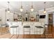 Bright kitchen features granite countertops, custom cabinets, and bar stool seating at 10915 Hermit Thrush Ln, Charlotte, NC 28278