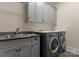 The laundry room features a sink, gray cabinets, and a washer and dryer at 10915 Hermit Thrush Ln, Charlotte, NC 28278