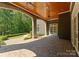 Covered porch with brick columns, ceiling fans, stone flooring and view of the manicured landscaping at 10915 Hermit Thrush Ln, Charlotte, NC 28278