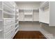 Well-organized walk-in closet featuring custom shelves and drawers for efficient wardrobe storage at 10915 Hermit Thrush Ln, Charlotte, NC 28278