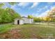 Rear view of home with an attached garage; the spacious backyard is enclosed by a chain-link fence at 1106 University Dr, Lancaster, SC 29720