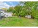 View of home and yard, surrounded by mature trees and greenery with a fenced yard at 1106 University Dr, Lancaster, SC 29720