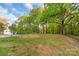 Expansive backyard features lush lawn and mature trees, all enclosed by a chain-link fence at 1106 University Dr, Lancaster, SC 29720