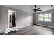 Clean bedroom with ceiling fan, large windows, light gray paint, and laminate floors, offering a serene retreat at 1106 University Dr, Lancaster, SC 29720