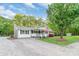 Charming single-story home with a welcoming front porch, lush landscaping, and a gravel driveway at 1106 University Dr, Lancaster, SC 29720