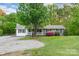 Charming single-story home featuring a cozy front porch, mature tree, and well-manicured lawn at 1106 University Dr, Lancaster, SC 29720