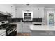 Bright kitchen with white cabinets, dark backsplash, stainless steel appliances, and ample counter space at 1106 University Dr, Lancaster, SC 29720