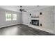 Inviting living room with a white brick fireplace and updated flooring, creating a warm and inviting space at 1106 University Dr, Lancaster, SC 29720