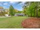 Expansive lawn area with mature trees and a small storage shed offers plenty of outdoor space at 1106 University Dr, Lancaster, SC 29720