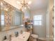 Bathroom with double sink vanity, decorative mirror, and modern lighting fixture at 1116 Montgomery Ave, Albemarle, NC 28001