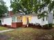 Charming single-story home featuring white siding, brick accents, and a cozy front porch at 1116 Montgomery Ave, Albemarle, NC 28001