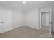 Carpeted bedroom with ensuite and walk in closet; neutral color scheme throughout at 113 Fosters Glen Pl, Mooresville, NC 28115