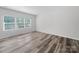 Sunlit bedroom with large windows and wood-look flooring at 113 Fosters Glen Pl, Mooresville, NC 28115