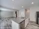 Modern kitchen island features a stainless steel dishwasher and double sink, opening to the living room at 113 Fosters Glen Pl, Mooresville, NC 28115
